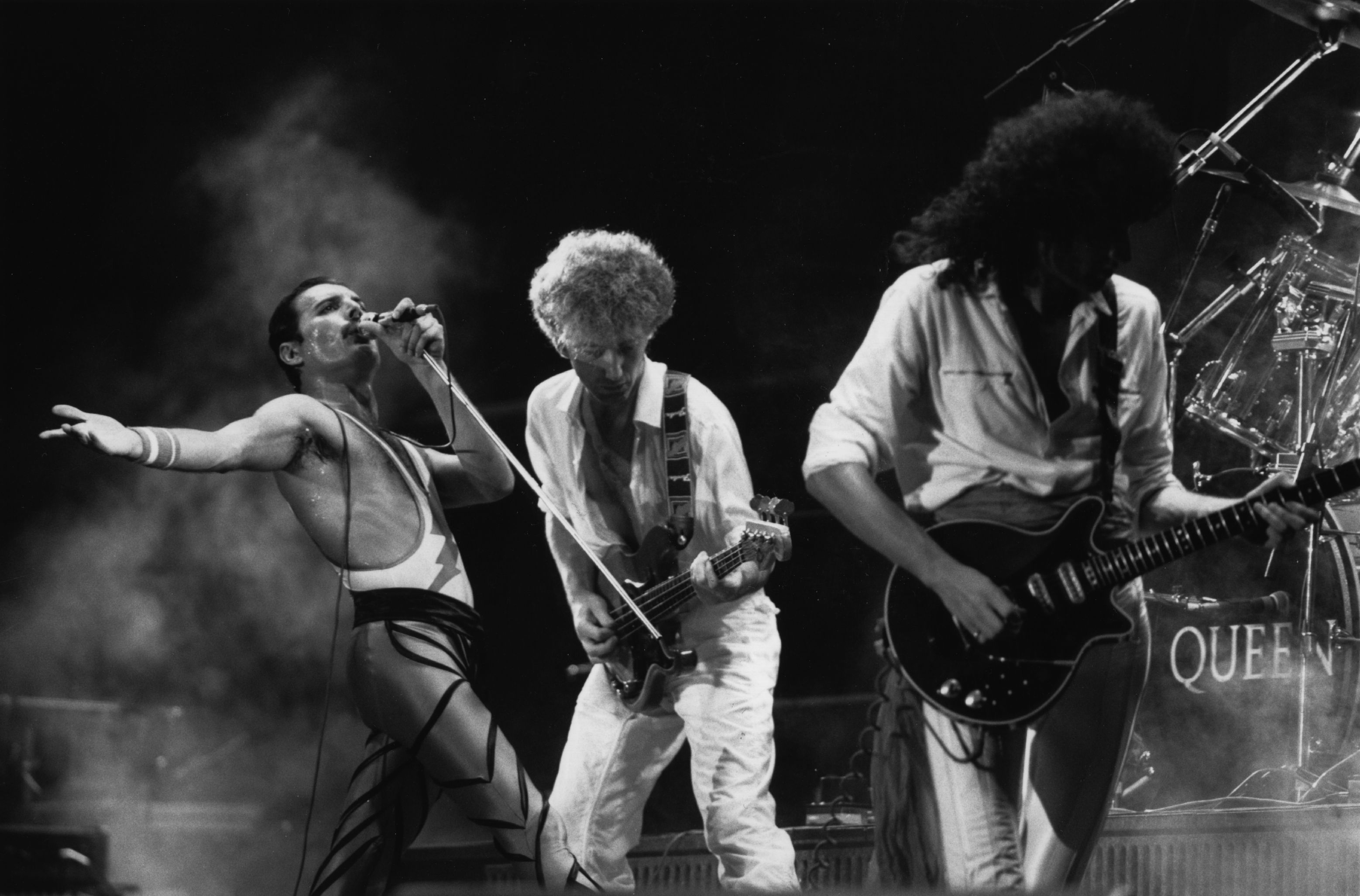 British rock group Queen in concert, from left to right; Freddie Mercury (Frederick Bulsara, 1946 - 1991), John Deacon, and Brian May.  Original Publication: People Disc - HU0463   (Photo by Express Newspapers/Getty Images)